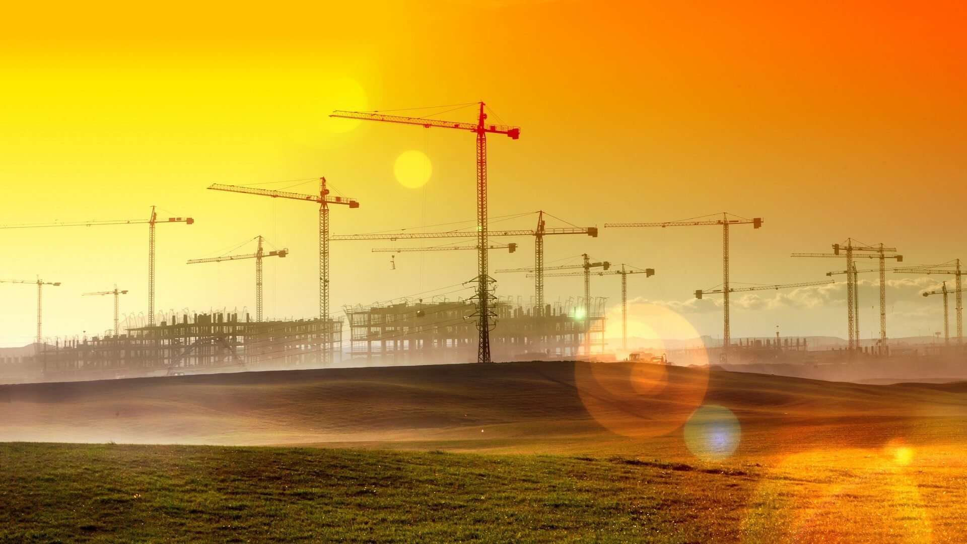 Paisaje de atardecer.Gruas y edificios en  construccion